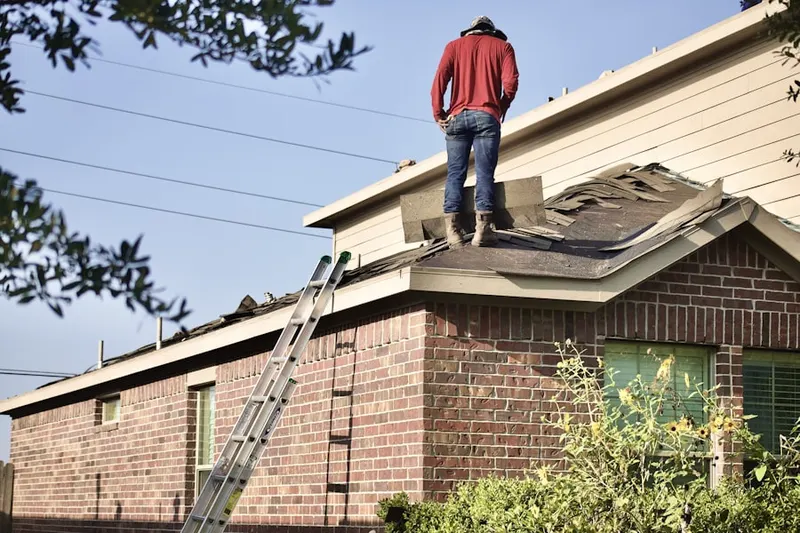 Professional roofer working on a residential roof in Taberg